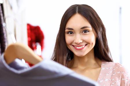 Portrait of young woman inside a store buying clothesの写真素材
