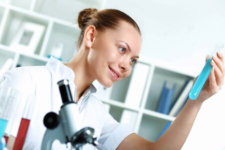Young scientist in white uniform working in laboratoryの写真素材