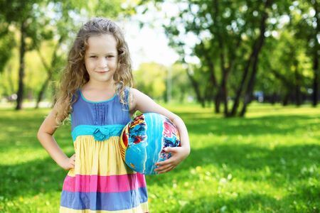 Little happy girl having fun in green summer parkの写真素材