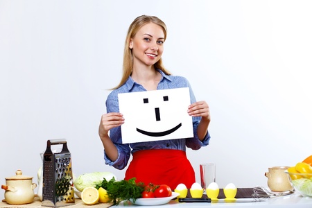 Young happy woman cooking fresh meal at homeの写真素材