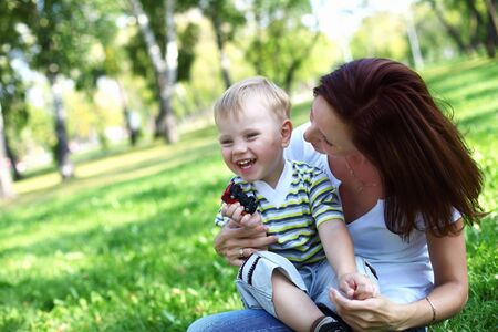 Young mother with her little son in summer parkの写真素材
