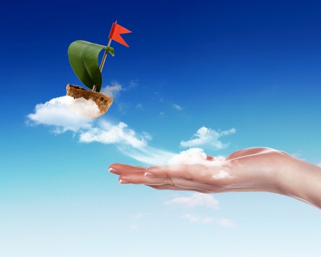 Nutshell ship with green leaf sail and red flagの写真素材