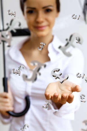 Collage with business woman under money rain with umbrellaの写真素材