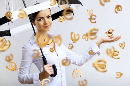 Collage with business woman under money rain with umbrellaの写真素材