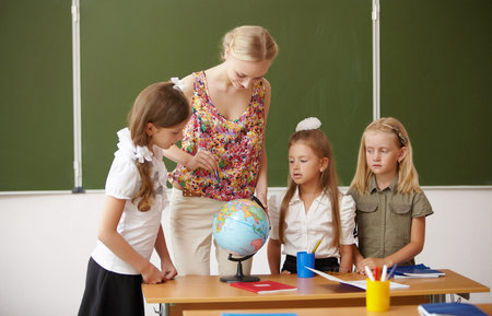 Young female teacher working with children at school