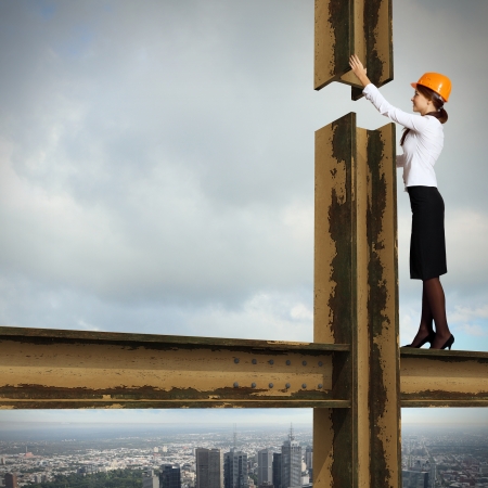 Business woman standing high over a cityscape の写真素材