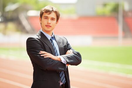 Satisfied smiling businessman standing in the summer outdoors の写真素材