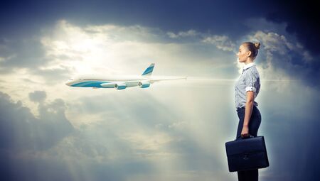 Busines person and plane on the background against cloudy skyの写真素材
