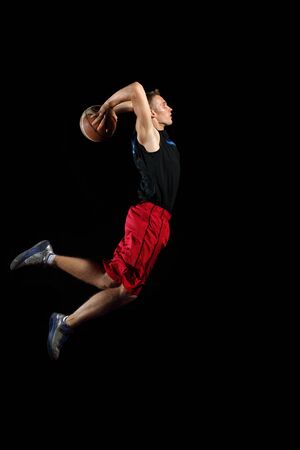 Male basketball player jumping and practicing with a ballの写真素材
