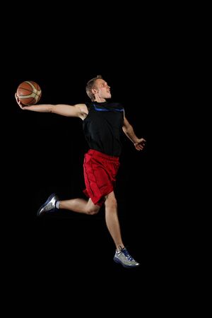 Male basketball player jumping and practicing with a ballの写真素材