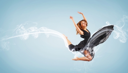 Portrait of a dancing young woman with smoke curles aroundの写真素材