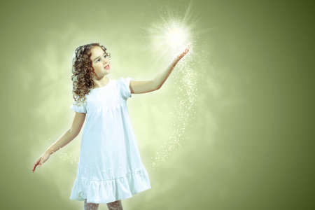 Little girl with magic lights and shining aroundの写真素材