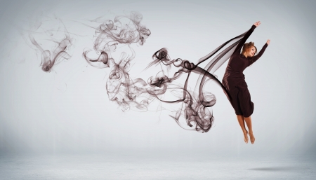 Beautiful young dancer with black smoke curles around herの写真素材