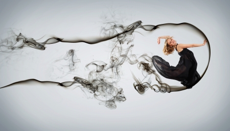 Beautiful young dancer with black smoke curles around herの写真素材