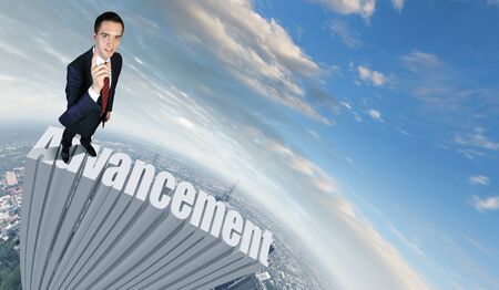 Businessman in suit standing on the word Advancementの写真素材