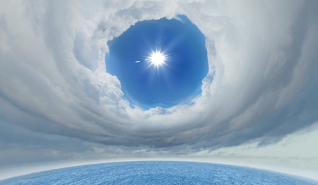 bright blue sky with sun shining and some cloudsの写真素材