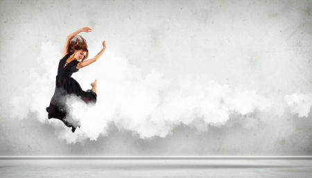 Portrait of a dancing young woman with white cloudy smoke aroundの写真素材