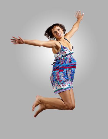 pretty modern slim hip-hop style woman jumping dancing on a colour backgroundの写真素材