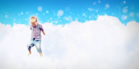 Photo of little boy jumping and raising handsの写真素材