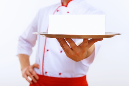Male cook in uniform holding an empty trayの写真素材