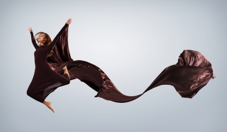 Portrait of a dancing young woman with black fabricの写真素材