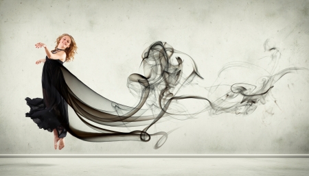 Beautiful young dancer with black smoke curles around herの写真素材