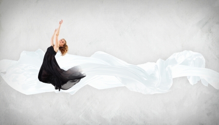 Portrait of a dancing young woman with white fabricの写真素材