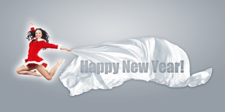 Happy smiling woman in red xmas costume jumping highの写真素材