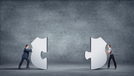 Team of business people collaborate holding up jigsaw puzzle pieces as a solution to a problemの写真素材