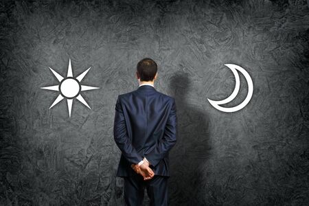 Businessman standing and making his choice between timesの写真素材