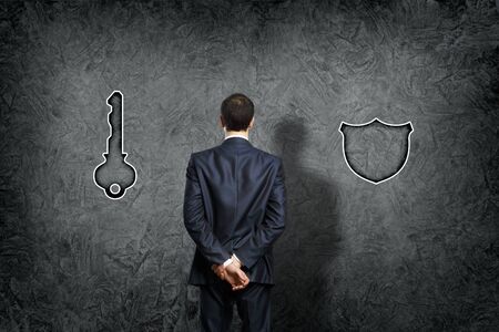 Senior businessman thinking and making choice while looking upの写真素材