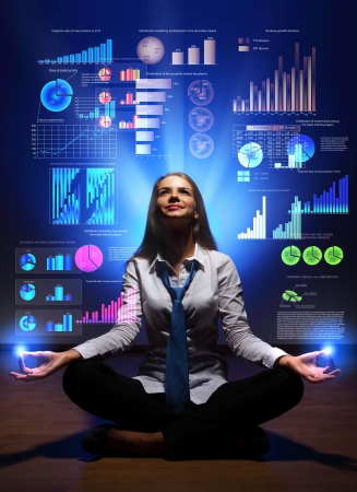 Businesswoman with financial symbols around her on the backgroundの写真素材