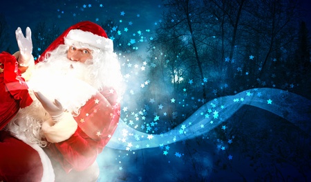 Santa with beard and red hat holding and looking into the sackの写真素材
