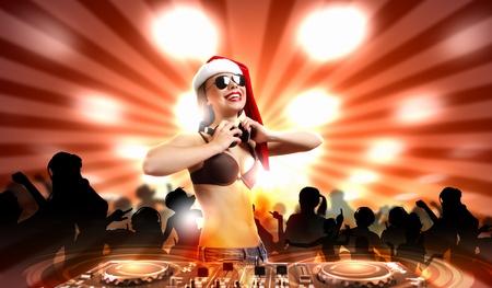 Young brunette woman in christmas wear with earphonesの写真素材