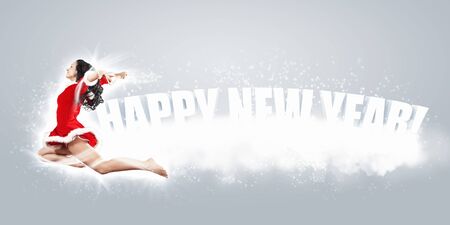 Happy smiling woman in red xmas costume jumping highの写真素材