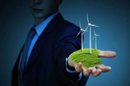 Business man and a windmills as a symbol of green energyの写真素材