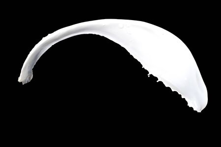 White milk splash isolated on black backgroundの写真素材