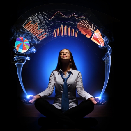 Businesswoman with financial symbols around her on the backgroundの写真素材