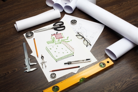 Tools and papers on the table with a picture of a houseの写真素材