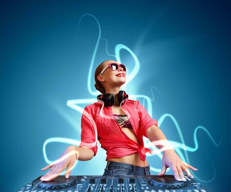 DJ with a mixer equipment to control sound and play musicの写真素材