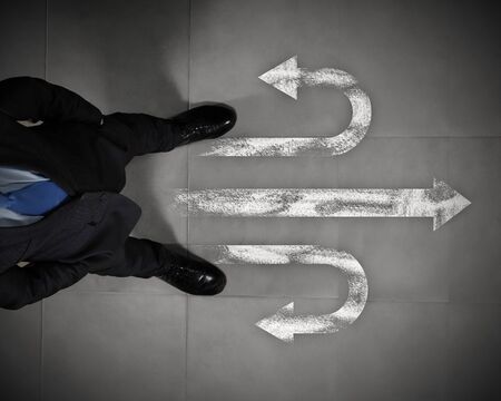 Top view of businessman standing against directions backgroundの写真素材