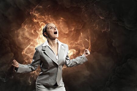 businesswoman in anger screaming against smoky backgroundの写真素材