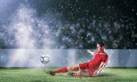 football player in red shirt striking the ball at the stadium