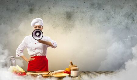 Asian female cook screaming loud in megaphoneの写真素材