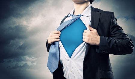 Image of young businessman showing superhero suit underneath his shirtの写真素材