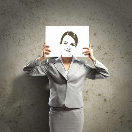 Image of businesswoman holding drawing against face  Conceptual photoの写真素材