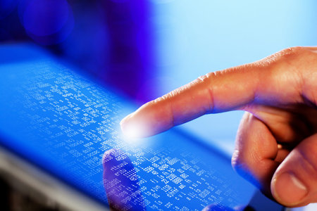Closeup of finger touching blue toned screen on tablet-pc