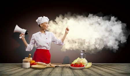 Asian female cook holding megaphone with space for textの写真素材