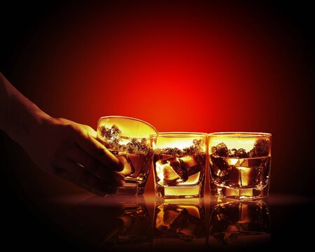 Hand holding one of three glasses of whiskey with nature illustration inの写真素材