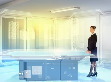 Image of young businesswoman standing aside of high-tech pictureの写真素材